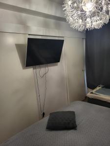 a bedroom with a bed with a television on the wall at Top in Oulu
