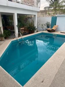 a swimming pool with blue water in front of a building at Chambre double meublée in Mbour