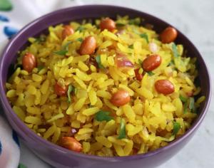 a bowl of yellow rice with beans and green onions at Hotel Sasa Paradise in Lucknow