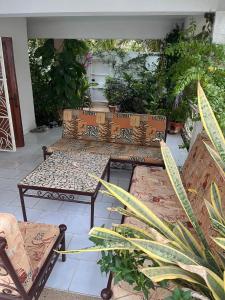 two benches sitting on a patio with plants at Chambre double meublée in Mbour +25 photos