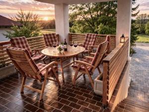 a wooden table and chairs on a patio with wine glasses at Hiša PRI JEZERU in Dobrovnik