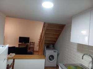 a kitchen and living room with a washing machine at Casa da Ti Joana in Aranhas