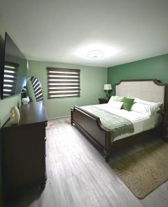 a bedroom with a bed with green walls and a piano at The Gatehouse Tobago in Buccoo +62 photos