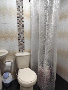 a bathroom with a toilet and a shower curtain at Casa Hotel Bijaos in Mompós +30 photos