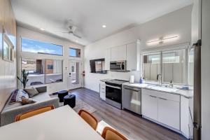 a kitchen with white cabinets and a table and a couch at The Riv at Zion in Virgin