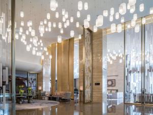 a lobby with a bunch of chandeliers hanging from the ceiling at 太原富力铂尔曼大酒店 in Taiyuan +161 photos