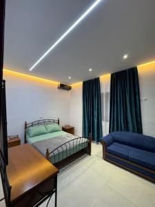 a bedroom with a bed and a blue couch at Azure Horizon in Çukë