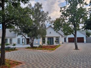 a white house with trees in front of it at Picasso Dreams in Kimberley