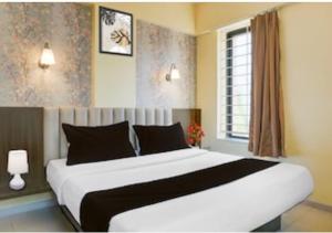 a bedroom with a large white bed with a window at POP 84342C Hotel Jashoda in Jodhpur
