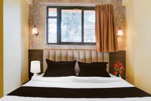 a bedroom with a large bed and a window at POP 84342C Hotel Jashoda in Jodhpur