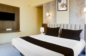 a bedroom with a large white bed with black pillows at POP 84342C Hotel Jashoda in Jodhpur