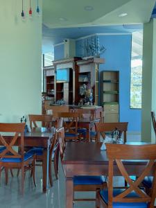 a dining room with wooden tables and chairs at Hotel Bahamas in Sarandë