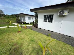 a white house with a grass yard in front of it at Villa Rio Grande in Santa Catalina