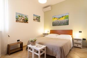 a bedroom with a bed and two paintings on the wall at Antico Camino B&B in Muro Leccese