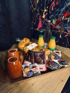 a table with a tray of breakfast foods and drinks at Love Room avec Jacuzzi Privatif Loft Sensation Romantique in Renwez