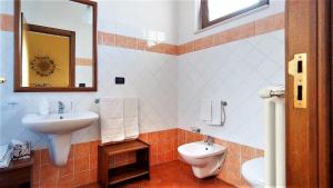 a bathroom with a sink and a toilet and a mirror at Antico Camino B&B in Muro Leccese