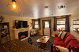a living room with a red couch and a fireplace at Historic Washington St Balcony in Sonora