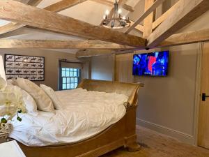 a bedroom with a bed and a tv on the wall at The old stables at flass in Maulds Meaburn