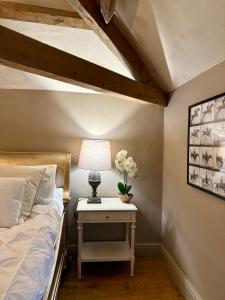a bedroom with a bed and a table with a lamp at The old stables at flass in Maulds Meaburn +12 photos
