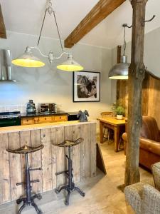 a kitchen with a counter and stools in a room at The old stables at flass in Maulds Meaburn