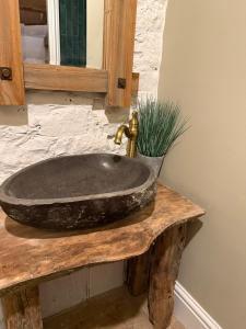 a stone sink on a wooden counter with a mirror at The old stables at flass in Maulds Meaburn