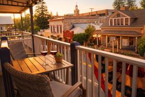 a balcony with a table with two glasses of wine at Historic Washington St Balcony in Sonora