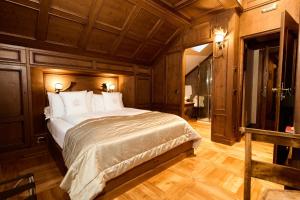 a bedroom with a large bed in a room with wooden floors at Ambra Cortina Luxury&Fashion Hotel in Cortina dʼAmpezzo +168 photos