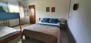 a bedroom with a bed with blue pillows on it at Karouti-Rooms for Rent in Pteleos