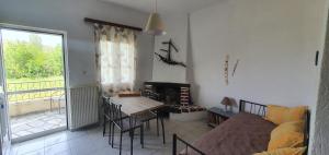 a living room with a bed and a table and a desk at Karouti-Rooms for Rent in Pteleos
