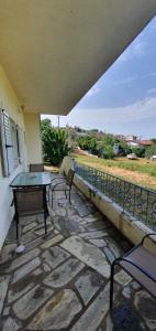 a patio with a table and chairs on a balcony at Karouti-Rooms for Rent in Pteleos