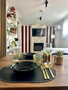 a wooden table with two plates and wine glasses on it at The Attic in Civitavecchia