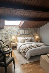 a bedroom with a large bed and a brick wall at Vestigia Nueva Castilla in Sigüenza