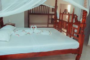 a bedroom with two bunk beds with white sheets at Villa Franet in Watamu +16 photos
