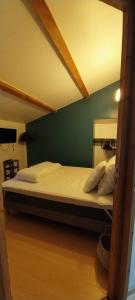 a bed in a room with a green wall at A L ESCALE PASSA PAÏS in Le Poujol-sur-Orb