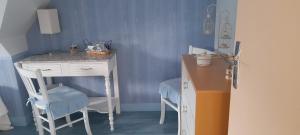 a blue room with a desk and a table and chairs at le moulin à vent in Céré-la-Ronde