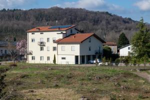 a large white house with a red roof at Casa Vacanze Aria 1 in Leggiuno