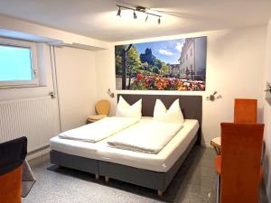 a bedroom with a bed with a painting on the wall at Gästehaus Sommertal, eigener Parkplatz, Pool, 800m zum Bodensee in Meersburg +51 photos