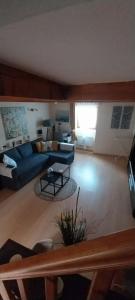 a living room with a blue couch and a table at A L ESCALE PASSA PAÏS in Le Poujol-sur-Orb