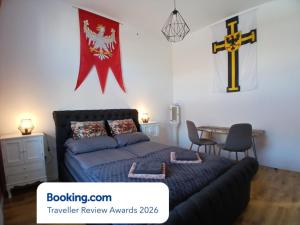 a bedroom with a bed and a cross on the wall at Apartamenty Zakonne "Apartament Komtura" in Malbork +7 photos