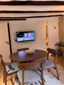 a dining room with a table and chairs and a tv at La Rambla in Albarracín