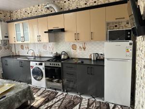 a kitchen with a stove and a refrigerator at Welcome home apartments in Samarkand +16 photos