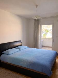a bedroom with a blue bed with a window at Apartment Tramonto Budva in Budva