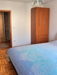 a bedroom with a bed and a wooden cabinet at Apartment Tramonto Budva in Budva +5 photos