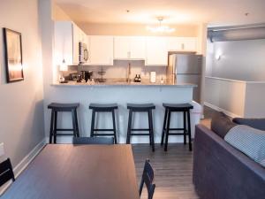 a kitchen and living room with a couch and a bar at Historic 2BR stay with patio & elevator in Indianapolis