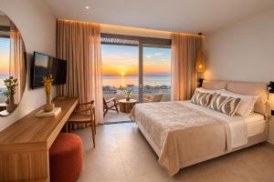 a bedroom with a bed and a desk and a television at Little Crab Suites in Agios Gordios