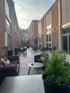 an outdoor patio with couches and tables and chairs at Hôtel Le Dormeur du Val in Charleville-Mézières