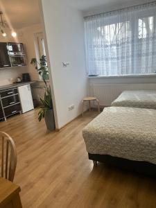 a bedroom with a bed and a kitchen and a table at Studio pod Orzechem in Zbąszyń