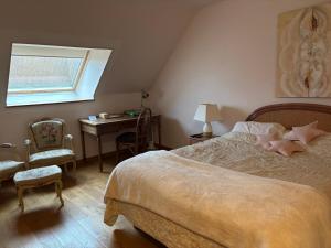 a bedroom with a bed and a desk and a window at Relais du Chat Prosper in Lescherolles