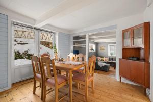 a dining room with a table and chairs at Hovedhuset in Kragerø