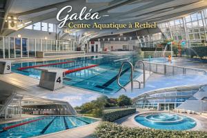 a large indoor swimming pool in a building at Le Cocon Rethelois. in Rethel